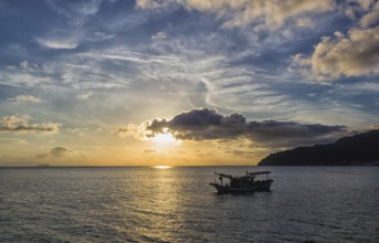 Sunset over the sea with two small boats. Malaysia