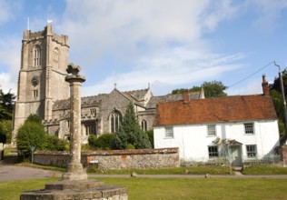 Church of St Michael and butter cross on the village green in Aldbourne, Wiltshire, England, United