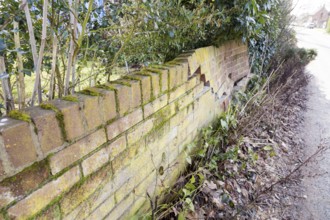 Impact damage to red brick garden wall caused by vehicle reversing, Suffolk, England, UK