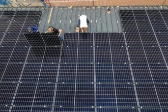 Installation of solar modules on the roof of a barn on a farm, over 210 photovoltaic modules are