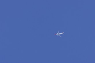 Boeing 737 aircraft flying across a blue sky, England, United Kingdom, Europe