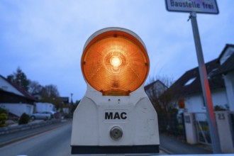 Warning light at a construction site in front of a village street, Eckental, Middle Franconia,