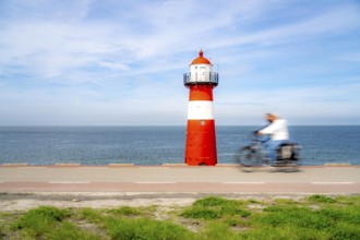 North Sea dyke near Westkapelle, Westkapelle Laag lighthouse, cyclists on the Zeeuwse Wind Route