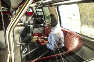 Business Woman Working on Laptop and Smartphone in First Class in a Train in Switzerland