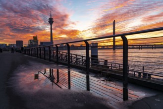 Winter sunset on the Rhine near Düsseldorf, riverside promenade at the old town, Rhine Tower, cargo