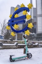 Winter in Frankfurt, euro sculpture on Willy-Brandt-Platz, snow-covered, e-scooter, Hesse, Germany,