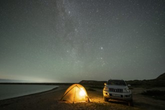 Off-road vehicle and tent, night shot, Milky Way at Lake Issyk Kul, Kyrgyzstan, Asia