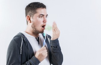 Man holding brush checking bad breath. Person holding brush with bad breath problem