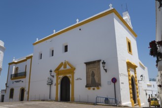 White church with yellow details, under a blue sky, in Mediterranean architectural style, Iglesia