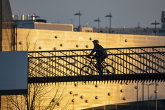 Cyclist on a bridge over Segerothstraße, in Essen, behind Limbecker Platz shopping centre