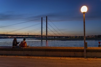 Evening on the banks of the Rhine in Düsseldorf, Rheinkniebrücke, skyline of Düsseldorf, with Rhine