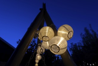 Lanterns, paper lanterns, fairy lights in a garden, blue hour, Germany, Europe