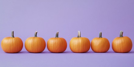 Small orange pumpkins in a row on pastel violet background. Generative Ai, AI generated