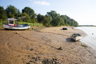 Fishing boat and dinghies beach at The Rocks on the River Deben near Ramsholt, Suffolk, England, UK