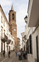 Church of Our Lady of the Assumption and people in village street, Aroche, Sierra de Aracena,