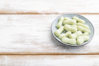 Jelly celery candies on white wooden background. copy space, side view, close up