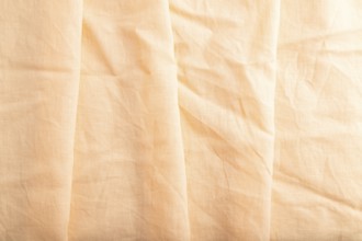 Fragment of orange linen tissue. Top view, natural textile background and texture. wave concept,