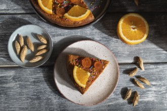 Orange cake on a gray wooden background. Hard light. contrast, low key. Top view, flat lay, close