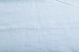 Fragment of smooth cotton blue tissue. Side view, natural textile background and texture