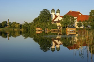 Romanesque Benedictine abbey Seeon monastery, monastery church St. Lambert with reflection in the