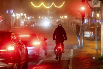 Cyclist, darkness, inner city traffic, Rüttenscheider Straße, bicycle lane, fog, autumn, winter,