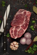 Pork neck, raw tenderloin, with spices, on the table, top view, no people, black background