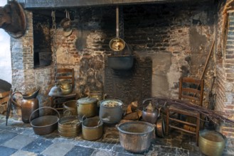 Old pots, cauldrons and kettles in hearth, open fireplace at kitchen inside Kasteel van Laarne,