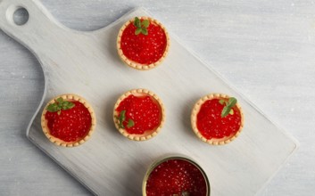 Tartlets with red caviar, on a light background, close-up, top view, no people