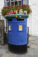 Blue Guernsey Post letterbox with emblem of Queen Elizabeth II in the church square in St Peter