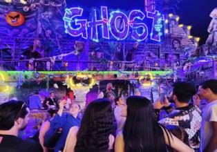 People in front of the illuminated ghost train Ghost in the evening, Cranger Kirmes, Herne, Ruhr