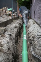 Construction worker, newly laid green sewage pipe, trench, Stuttgart, Baden-Württemberg