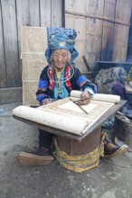 Vietnamese woman from the Hmong minority draws a pattern on linen fabric, Lung Tam linen weaving