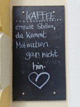 Advertising sign at an inn, coffee reaches places where motivation does not reach, slate sign