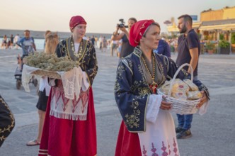 Traditionally dressed Greek women carrying gifts during marriage celebration, Chania, Crete, Greek