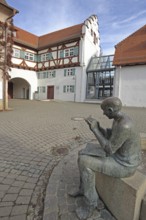 Historical town library with stepped gable and fountain with sculpture newspaper reader, Pfleghof,