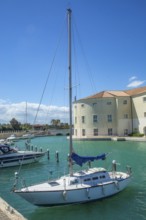 Sailboat at quay at Hotel Marinagri in Lido di Policoro resort, Basilicata, Mediterranean Sea,