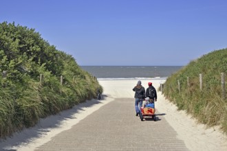 Two holidaymakers with handcart on Baltrum, East Frisia, Lower Saxony, Federal Republic of Germany