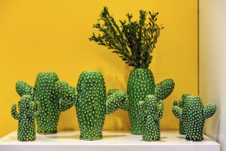 Green cactus vases in a yellow display case, vases in the shape of cacti, souvenir shop in the