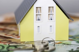 Concept photo with model house, euro notes and coins