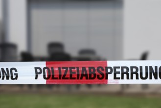 Symbolic image: Barrier tape with the inscription police cordon, in the background a residential