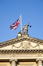 Union Jack flag flying with britannia holding scales of Justice on top of the Guildhall building,