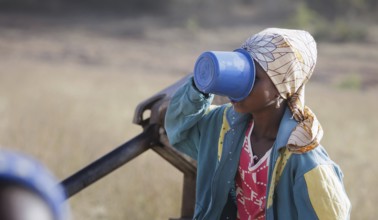 Young woman, girl drinking water from a plastic cup in Maraban Dare community in Plateau state,