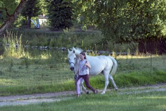 Girl, 10 years old leads her horse on the lead, Othenstorf, Mecklenburg-Vorpommern, Germany, Europe