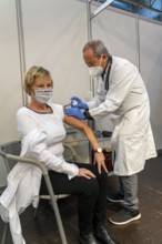 Vaccinator administers a vaccination, during the test run in the vaccination centre for corona