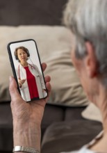 Symbolic image of telemedicine, patient speaks to a doctor in a video conference from home via