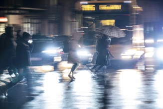 Passers-by at a pedestrian crossing, at the main railway station, rainy weather, city centre, in