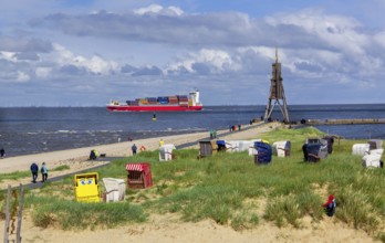 Beach promenade with landmark Kugelbake and container ship in the district of Döse, North Sea spa