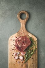 Fresh, raw rib eye steak, on a chopping board, top view, no people