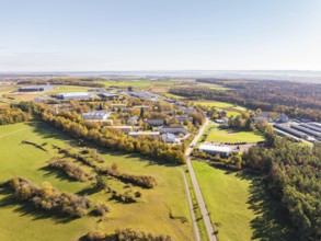 Industrial area next to fields and autumnal forest, seen from above, high ropes course, Nagold,