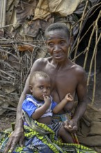 Pygmy woman of the Baka or BaAka people with her child in front of her hut, Bayanga, Sangha-Mbaéré